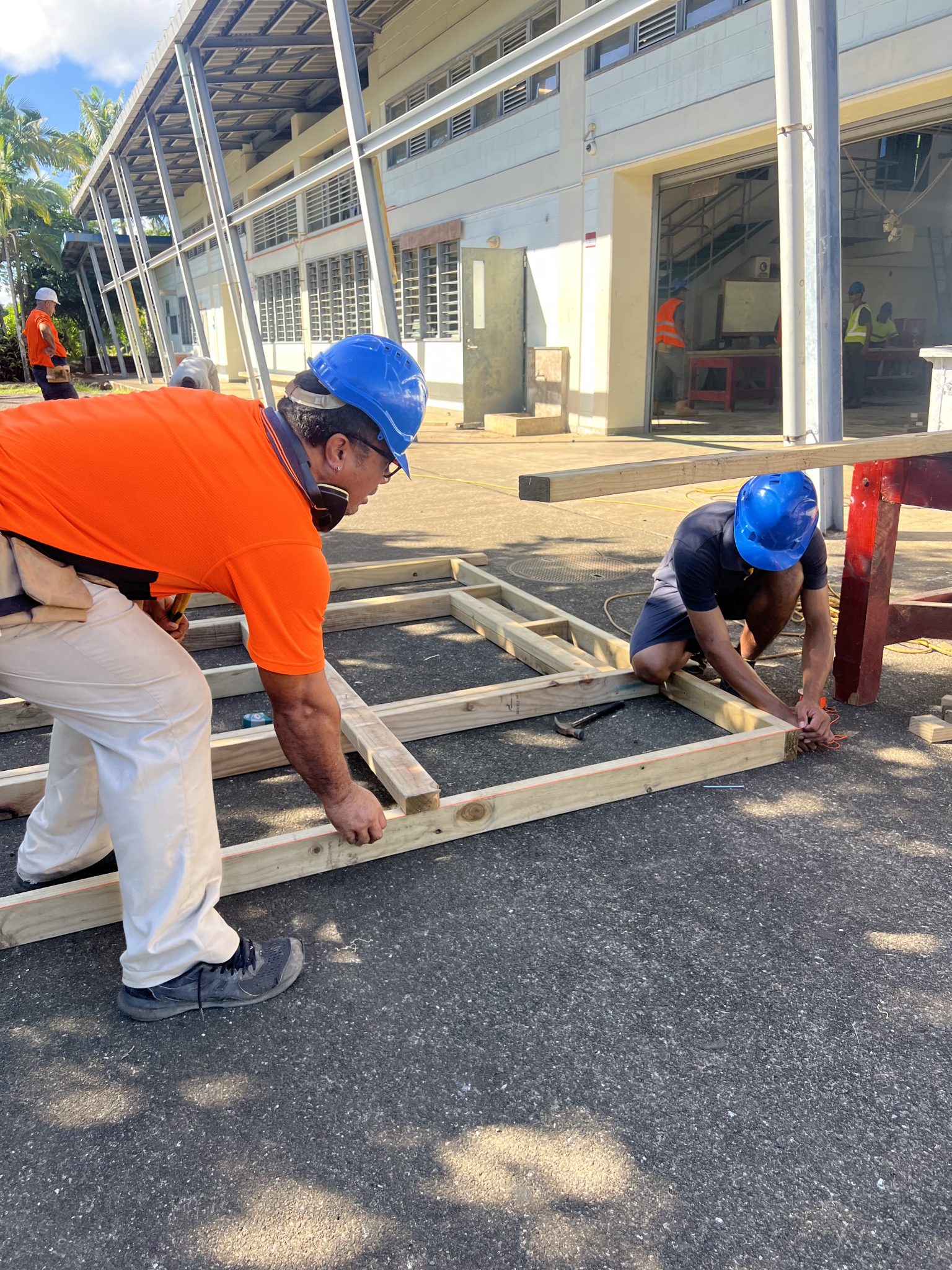 Participants laying out floor framing on the concrete apron.