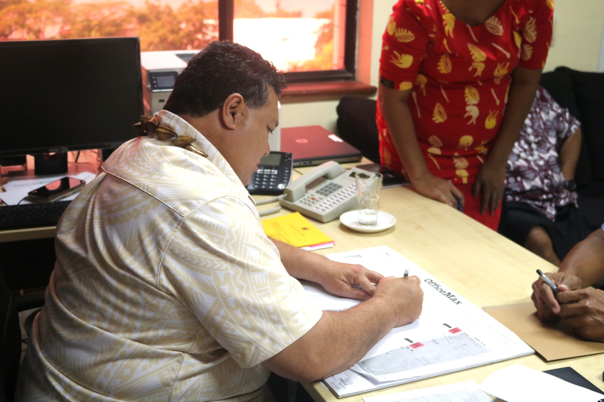 A newly appointed Commissioner signing his contract during the ceremony.