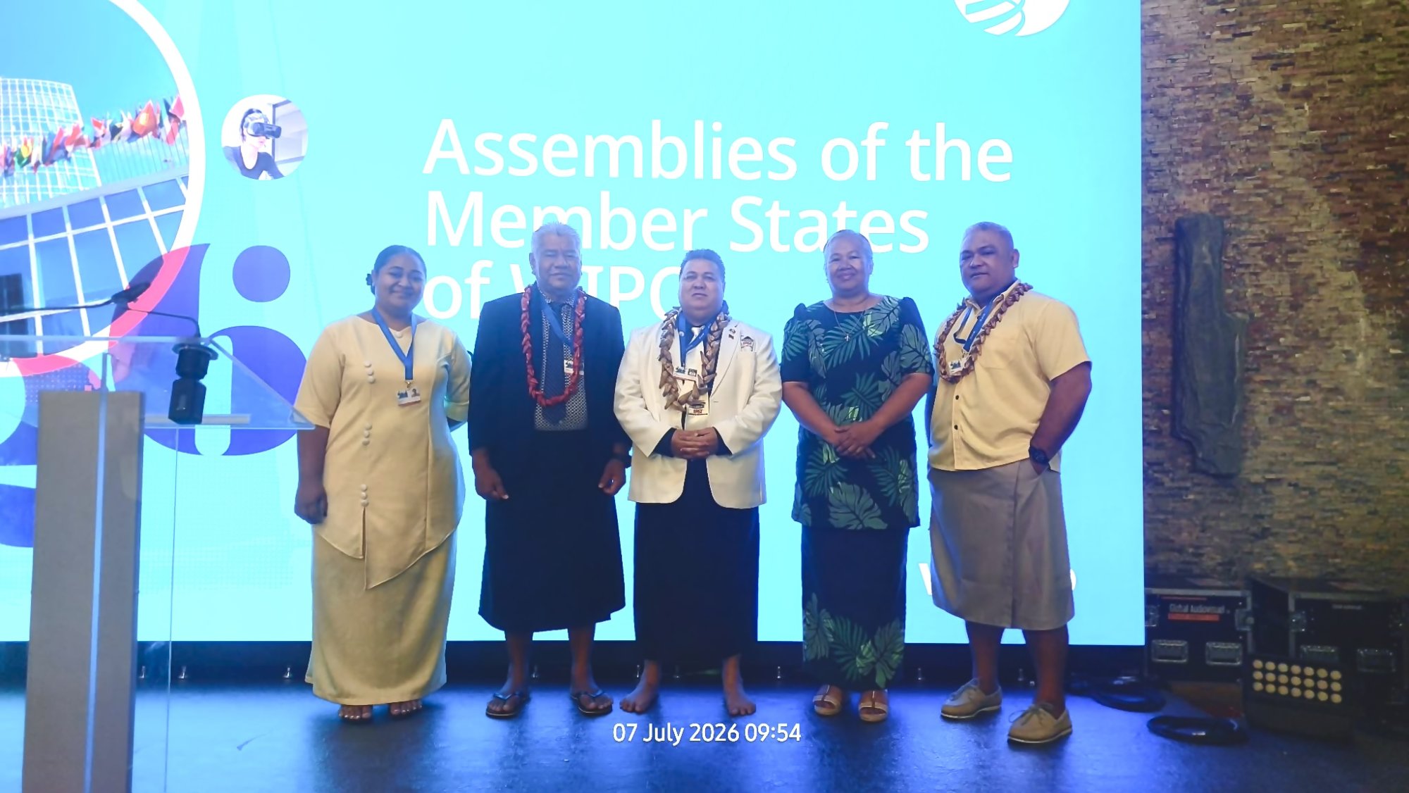 Samoa's delegation to the 68th WIPO Assemblies stands before the WIPO backdrop in Geneva dressed in formal Samoan attire.